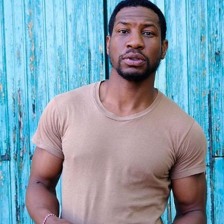 Jonathan Majors wears a tshirt while posing for a picture